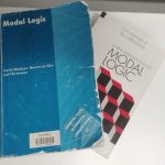 The textbook 'Modal Logic' by Patrick Blackburn, Maarten de Rijke, and Yde Venema, on top of another textbook, 'A New Introduction to Modal Logic' by G.E. Hughes and M. J. Cresswell